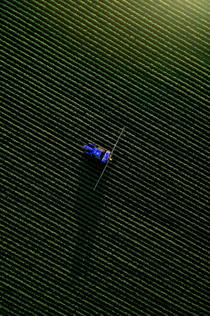 Drone shot of a tractor working in lush green fields in Koufalia, Greece.